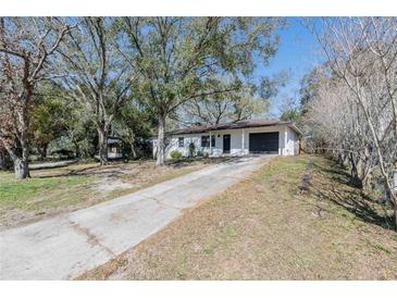 Charming single-story home with black garage door, front door, and a long driveway at 320 E Daughtery Rd, Lakeland, FL 33809