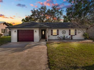 Charming one-story home with a well-manicured lawn and decorative shutters at 327 Corona Del Mar St, Lakeland, FL 33809