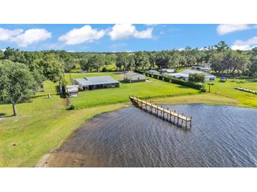 Waterfront property with a long pier and beautiful lake views from an aerial perspective on a bright and sunny day at 5418 Cooper Ln, Fort Meade, FL 33841