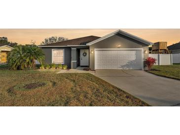 Charming single-story home featuring a two-car garage, a well-manicured lawn, and a welcoming front entrance at 8185 Woodvine Cir, Lakeland, FL 33810