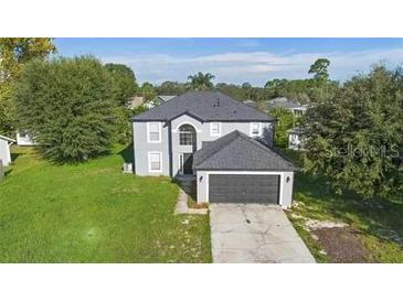 Two-story home with a gray roof, lush green lawn, and a two-car garage at 186 Rosedale Dr, Deltona, FL 32738