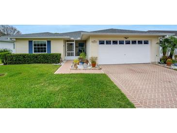 Charming home featuring a well-maintained lawn, brick driveway, and attached two car garage at 2173 Mission Hills Dr, Lakeland, FL 33810