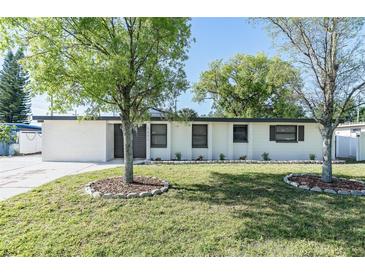 Charming single-story home with a well-maintained lawn and shade trees in a suburban neighborhood at 2521 Coral Way, Lakeland, FL 33801
