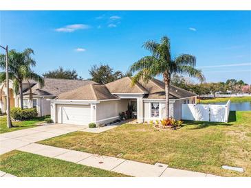 Charming single Gathering home with a two car garage, mature palm trees, and well-maintained landscaping at 3882 Rollingsford Cir, Lakeland, FL 33810