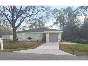 Charming single-story home featuring a neutral color scheme, attached garage, and well-maintained front lawn at 406 Fox Lake Dr, Lakeland, FL 33809