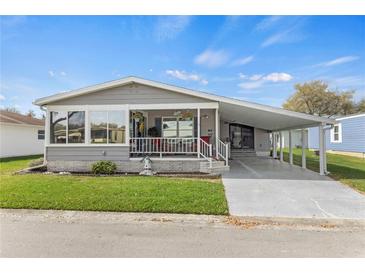 Charming single-story home features a covered carport, front porch, and well-maintained lawn at 4911 Colonnades Club Blvd, Lakeland, FL 33811