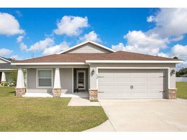 Charming single-story home with a well-manicured lawn, two-car garage, and inviting front entrance at 554 Lorient Dr, Eagle Lake, FL 33839