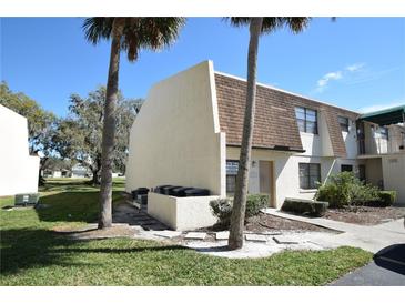 Inviting townhouse featuring a well-maintained lawn and mature trees in a serene community at 6043 Topher Trl # 6043, Mulberry, FL 33860