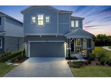 Charming two-story home with a grey exterior, well-manicured lawn, and an attached two-car garage at 6249 Great Bear Dr, Lakeland, FL 33805