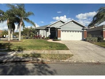 Charming single-story home featuring a well-manicured lawn, mature landscaping and a two-car garage at 7104 Lake Eaglebrooke Way, Lakeland, FL 33813