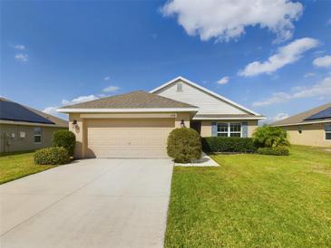Charming single-story home featuring a well-manicured lawn, neutral color palette, and a spacious two-car garage at 1134 Legatto Loop, Dundee, FL 33838