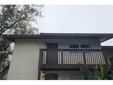 Two-story condo featuring a private balcony with wood railing and neutral exterior paint at 141 Fernery Rd # B5, Lakeland, FL 33809