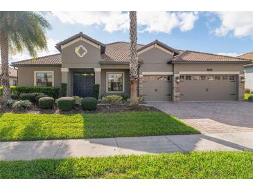 Charming single-story home with a tile roof, well-manicured lawn and a three-car garage at 1420 Mickelson Ct, Davenport, FL 33896