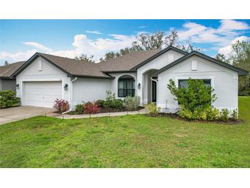 Close-up of a well-maintained single Gathering home, featuring an attached garage and manicured lawn at 153 Heritage Park Ln, Mulberry, FL 33860