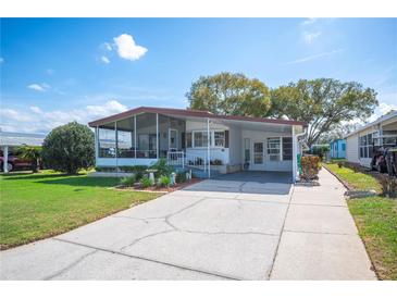 Charming single-story home with a screened porch, carport, landscaping, and a driveway at 1610 Reynolds Rd # 378, Lakeland, FL 33801