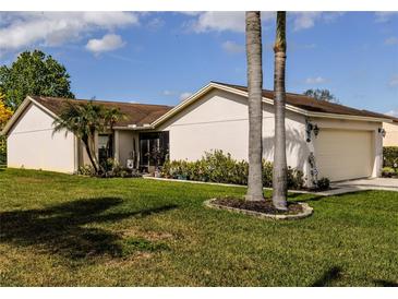 Charming single-story home with lush green lawn and well-maintained landscaping in a serene setting at 3976 Cypress W Lndg, Winter Haven, FL 33884