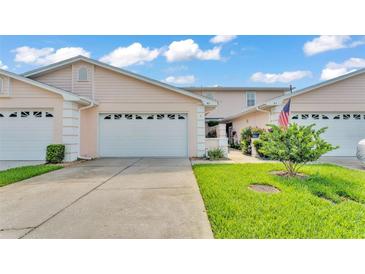 Charming townhome features a well-maintained lawn and a two-car garage at 42 Enclave Dr, Winter Haven, FL 33884