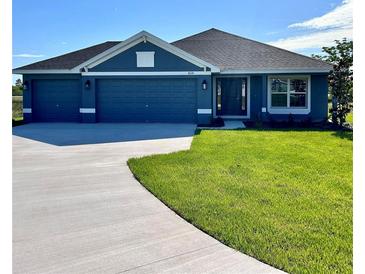 Charming blue single-story home with a well-manicured lawn and a three-car garage, perfect for Gathering living at 4202 Teeling Ct, Auburndale, FL 33823