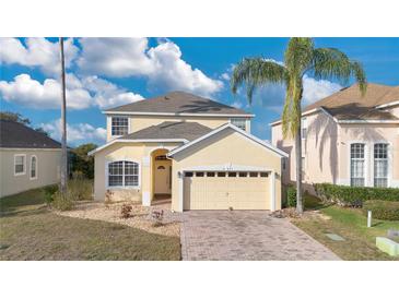 Charming two-story home featuring a well-manicured lawn, brick driveway and attached two-car garage at 435 Gleneagles Dr, Davenport, FL 33897