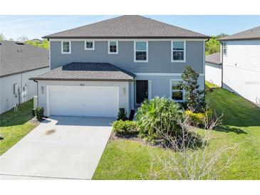 Two-story home with a well-manicured lawn, a two-car garage, and a gray exterior at 5531 Keaton Springs Dr, Lakeland, FL 33811