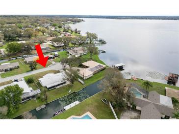 Aerial view of a waterfront home with a metal roof on a canal with easy access to a large lake at 5716 Gibson Shores Dr, Lakeland, FL 33809