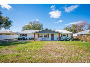 Charming single-story home featuring a metal roof, painted brick, and a welcoming front porch at 5716 Gibson Shores Dr, Lakeland, FL 33809