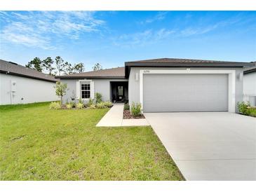 Charming single-story home with well-manicured lawn and a two-car garage at 6296 Dolostone Dr, Lakeland, FL 33811