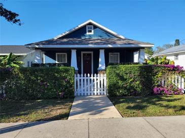 Charming blue home with a well-manicured front yard and a white picket fence at 631 W Park St, Lakeland, FL 33803