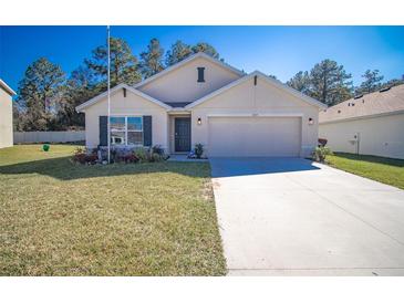 Charming single-story home featuring a well-maintained lawn and attached two-car garage at 6769 Se 3Rd Loop, Ocala, FL 34472