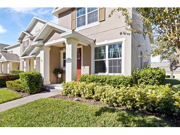 Charming two-story home features well-maintained landscaping, a red front door, and inviting curb appeal at 14439 Prunningwood Pl, Winter Garden, FL 34787