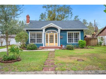 Charming blue home with a brick path leading to a bright yellow front door at 1618 Robertson St, Lakeland, FL 33803