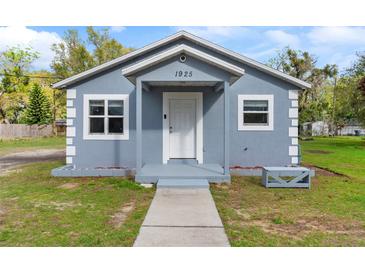 Charming single-story home featuring a light blue exterior, covered entryway, and well-maintained lawn at 1925 N Combee Rd, Lakeland, FL 33801