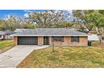 Charming single-story brick home featuring a well-maintained front yard and attached garage at 2330 Peterson Rd, Lakeland, FL 33812