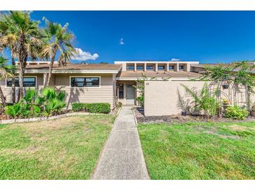 Inviting single story home featuring lush landscaping, a walkway, and a light beige exterior at 5225 Imperial Lakes Blvd # 49, Mulberry, FL 33860