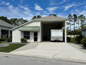 Charming single-story home featuring a covered carport and well-maintained landscaping at 1155 Motorcoach Dr, Polk City, FL 33868