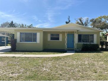 Charming single-story home featuring a blue front door, covered entry, and a well-manicured lawn at 2007 9Th Ne St, Winter Haven, FL 33881