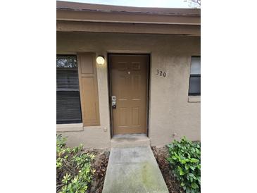 A front exterior door with a cemented walkway entrance to unit 320 at 320 Eron Way # 6, Winter Garden, FL 34787