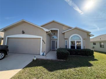 Charming single-story home with a manicured lawn, attached garage and welcoming front entrance with updated landscaping at 6059 Swallow Dr, Lakeland, FL 33809
