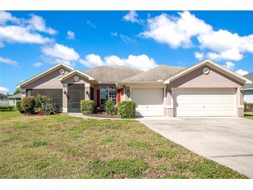 Charming single-story home featuring a two-car garage, well-manicured lawn, and delightful landscaping at 107 Amber Blvd, Auburndale, FL 33823