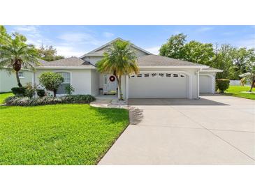 Charming single-story home with a well-manicured lawn, mature landscaping, and a three-car garage at 117 Belmont Dr, Winter Haven, FL 33884