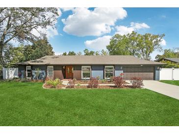 Charming single-story home featuring a well-manicured lawn, complemented by mature landscaping and a two-car garage at 1722 High Point Dr, Lakeland, FL 33813