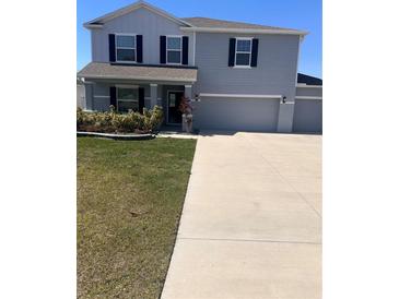 Two-story home featuring a spacious driveway, well-maintained lawn, and a two-car garage at 1921 Bell Creek Loop, Fruitland Park, FL 34731