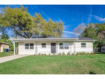 Charming single-story home featuring a well-manicured lawn and neutral-toned exterior with black door at 2924 Bellwood Ave, Lakeland, FL 33803