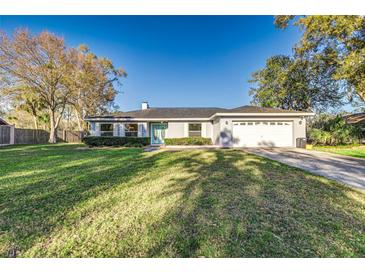 Charming single-story home with a well-manicured front lawn and a welcoming light blue front door at 4120 Old Colony Rd, Mulberry, FL 33860