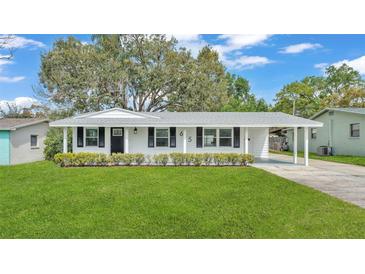 Charming single-story home with a well-manicured lawn and black shutters at 615 Carey Pl, Lakeland, FL 33803