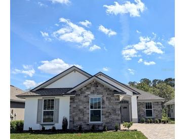 Beautiful single-story home with stone accents, well-manicured lawn, and paver driveway at 7903 Lake James Blvd, Lakeland, FL 33810