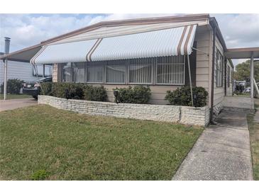 Charming single-story home featuring an awning, neutral siding, and well-kept front yard landscaping at 1007 Forest Lake Dr, Lakeland, FL 33809