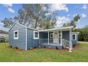 Charming home featuring a quaint porch with white railings and fresh landscaping at 1115 S Virginia Ave, Bartow, FL 33830