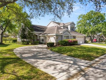 Beautiful two-story home features a well-manicured lawn and a circular driveway framed by mature trees at 1134 Waterfall Ln # 66, Lakeland, FL 33803