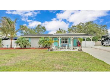 Charming single-story home featuring a covered entrance, vibrant turquoise accents, and lush landscaping at 1160 Ilene Ave, Bartow, FL 33830